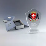 Trophée en verre transparent avec emblème de la ville, gravé avec le nom et le titre du récipiendaire.