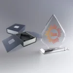 Trophée en verre en forme d’iceberg avec un logo coloré et le message “Réinventer le Monde”.