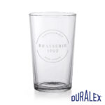 Verre à bière Duralex Unie 56 cl personnalisé Verre à bière Duralex Unie 56 cl transparent avec le logo circulaire Brasserie 1902 sur la face avant.